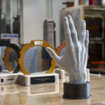 The hand statuette and the gate-shaped Future Gate 2026 awards in the PrusaLab workshop The hand statuette and the gate-shaped Future Gate 2026 awards in the PrusaLab workshop